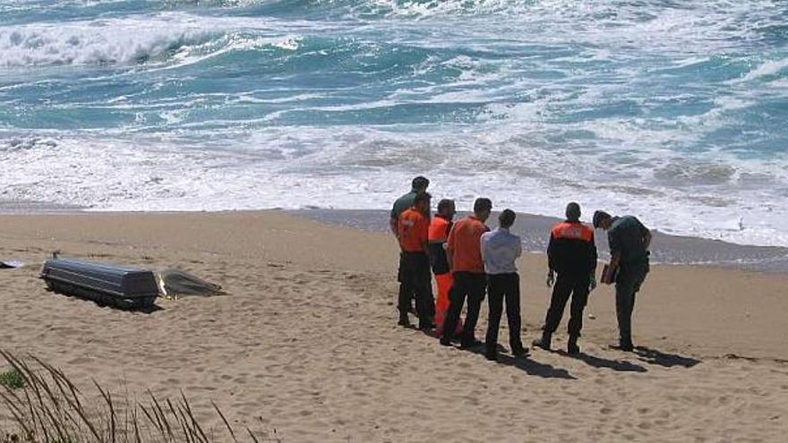 El cadáver localizado ayer en la playa y miembros de Protección Civil y de la policía. / m. c. s.