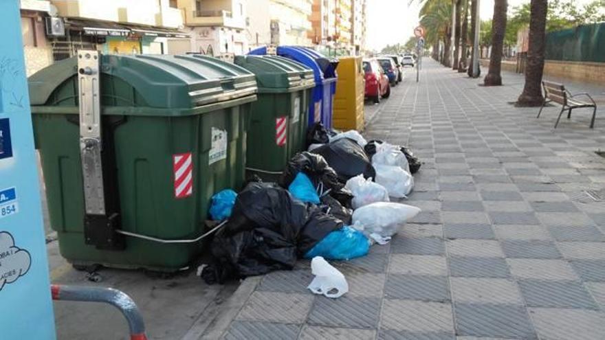 Basura junto a  contenedores vacíos