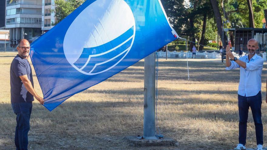 Los ediles de Medio Ambiente y Turismo izando la bandera azul en la playa Compostela.