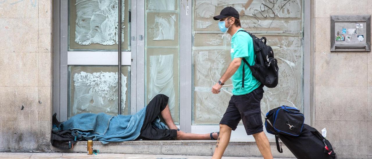 Una persona duerme en la calle, en una céntrica avenida de Alicante