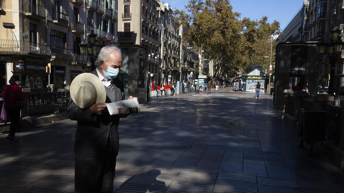 Un hombre lee el diario en una Rambla prácticamente vacía, el pasado miércoles. 