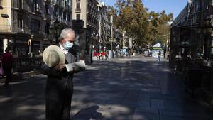 Un hombre lee el diario en una Rambla prácticamente vacía, el pasado miércoles. 