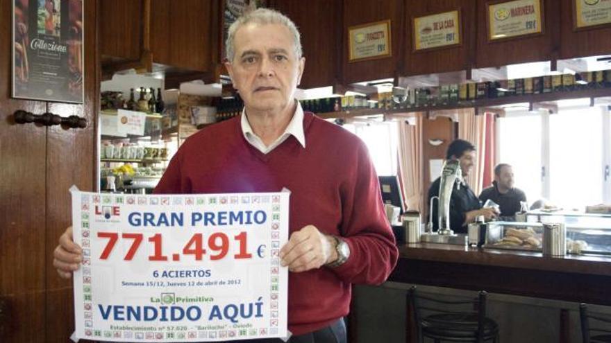 Ricardo García, en la cafetería Bariloche, con el cartel del premio de la lotería primitiva.