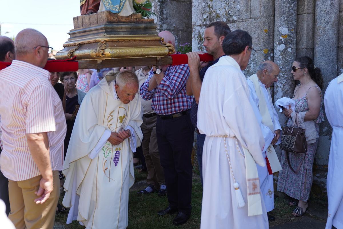 El sacerdote Luis Galego pasa bajo las imágenes.