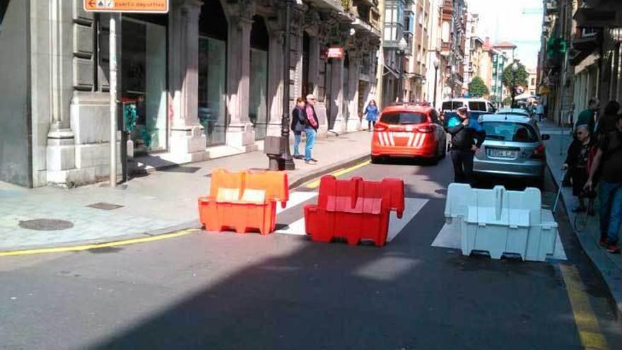 A la izquierda, barreras móviles y un coche de la Policía Local de Gijón impiden el paso por la calle San Bernardo. A la derecha, el mismo bloqueo en Marqués de San Esteban a la altura de Felipe Menéndez.