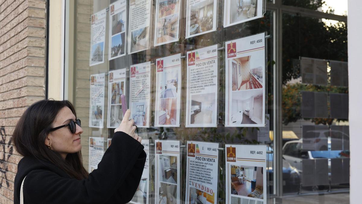 Una joven consulta el precio de los pisos en Valencia.