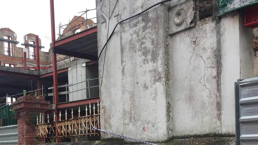 Las piedras desprendidas de la fachada sobre la acera de la calle Luis Muñiz y la cinta colocada por la Policía Local.