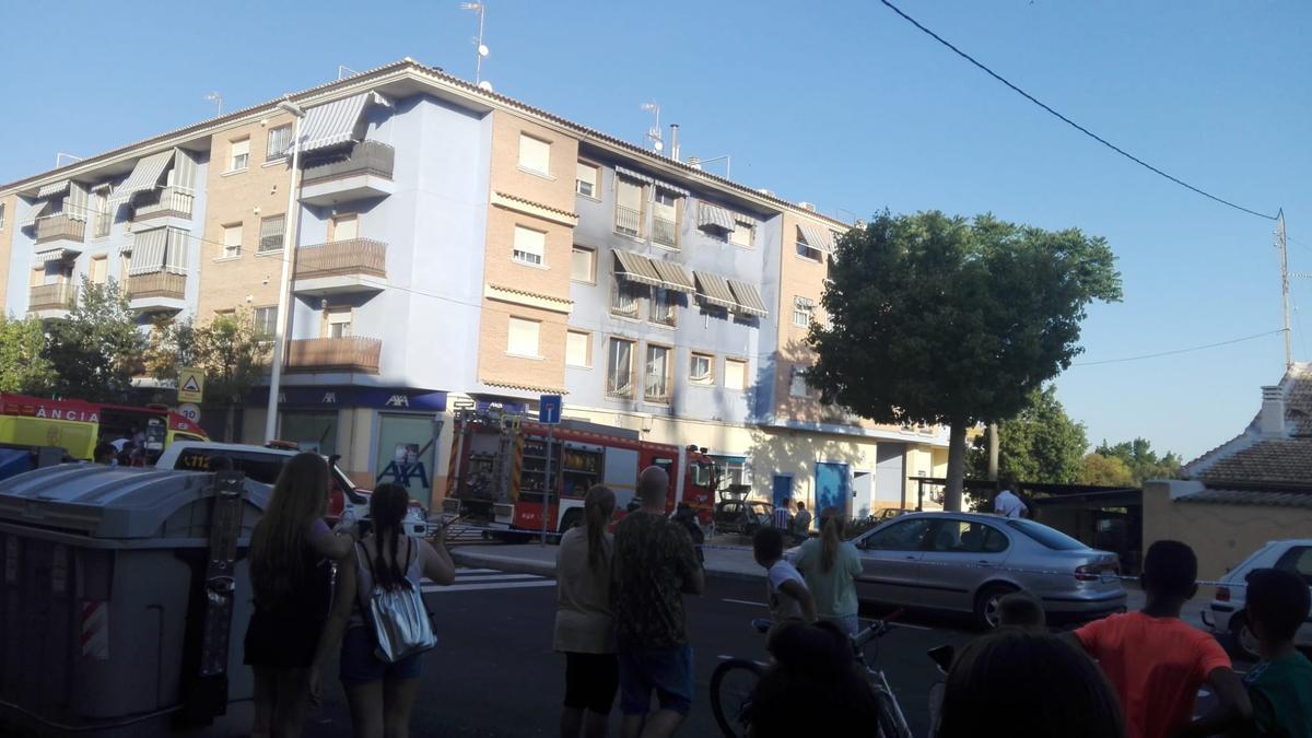 Vecinos de Torrellano observando cómo los bomberos sofocan las llamas del vehículo