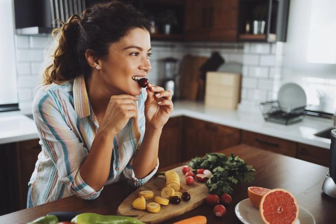 Foto de mujer comiendo fruta