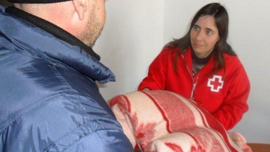 La tècnica de Creu Roja Manresa Anna Budia lliura mantes a un usuari