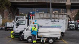 Un operario municipal de limpieza junto a la flota de vehículos del sistema de recogida de basuras de Mataró, en enero de 2024