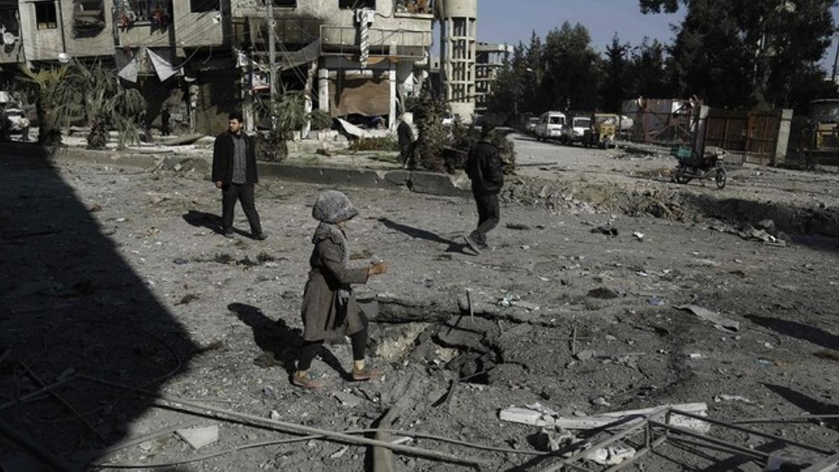 Una niña camina entre los escombros tras un bombardeo a las afueras de Damasco.