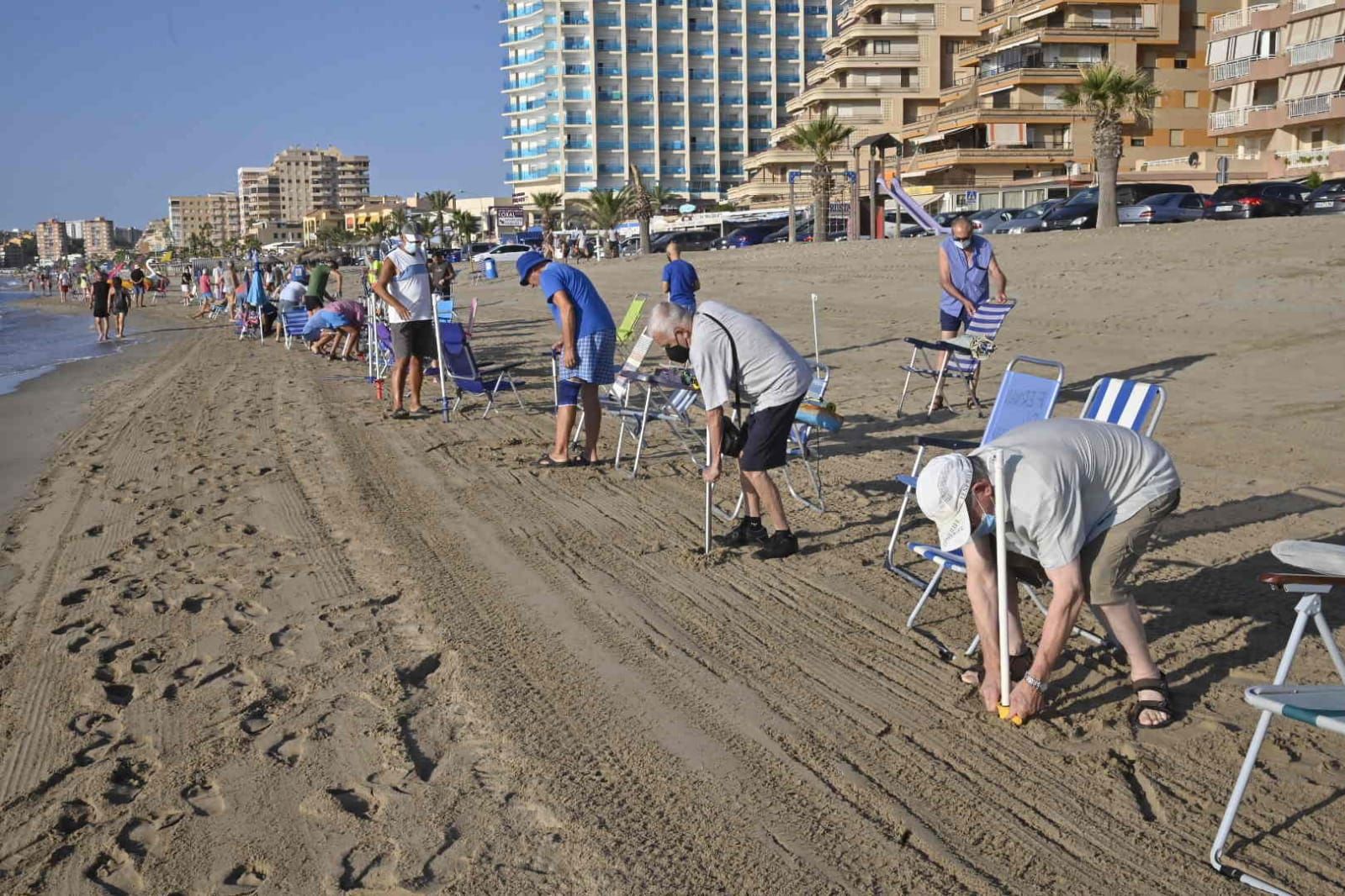 Los agentes actúan para evitar que los usuarios reserven primera línea de playa con las sombrillas