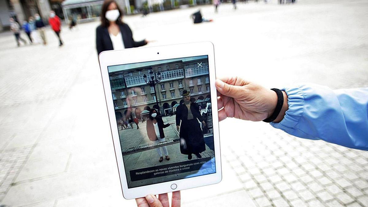 Inés Rey, acompañada por una Pardo Bazán virtual en un iPad en la plaza de María Pita.   | // CABALAR