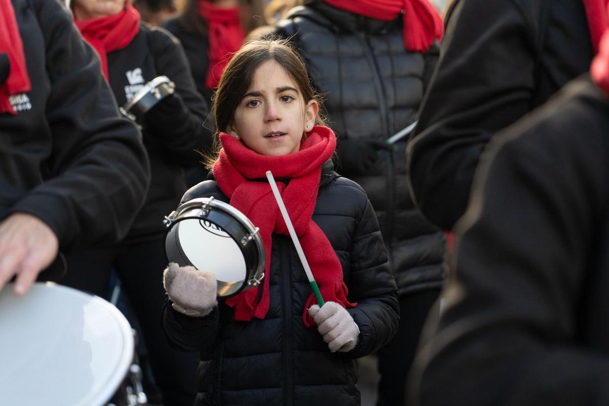 Una niña desfila con un grupo de música en la cabalgata de Ontinyent.