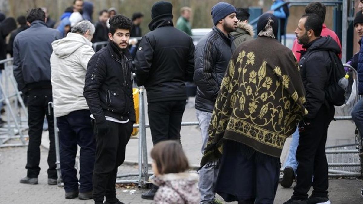 Migrantes esperan para registrarse frente a la oficina federal de migración y refugiados del distrito de Spandau, en Berlín (Alemania).