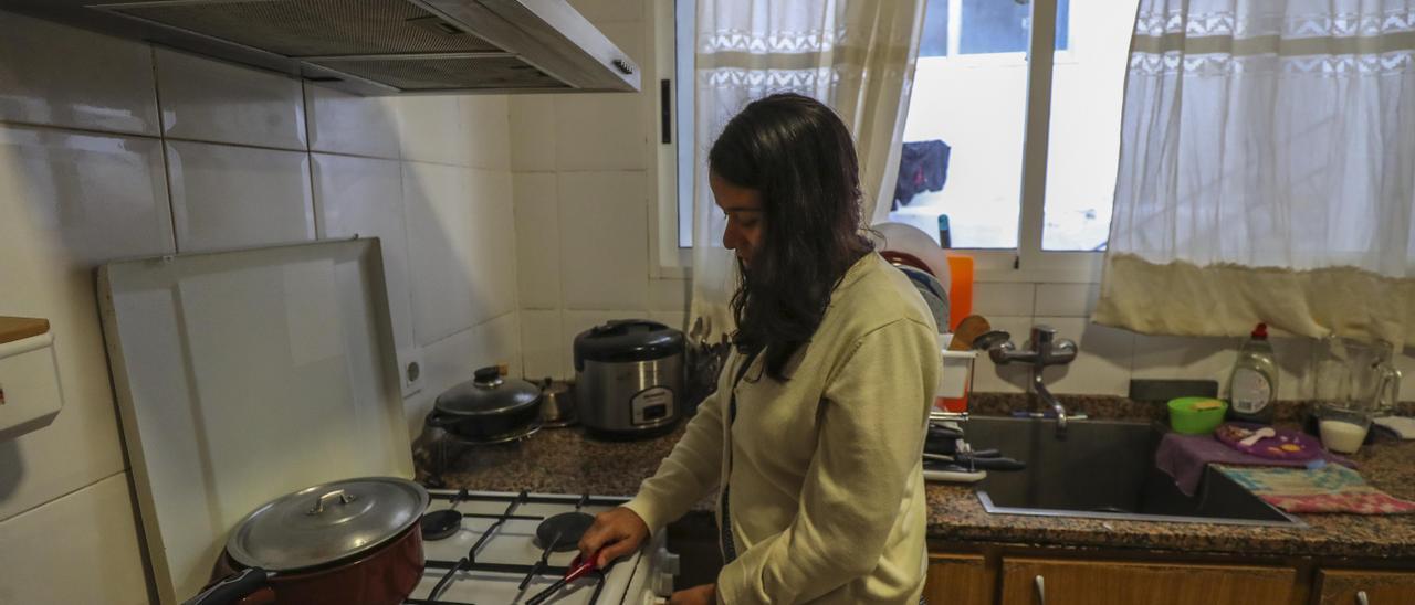 Una mujer enciende el fuego de su cocina para preparar comida.