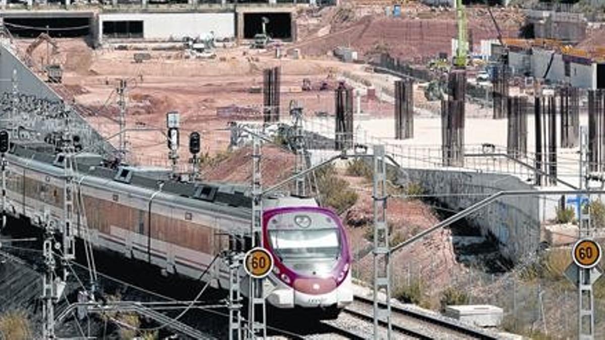 Un tren circula junto a las obras de la estación de la Sagrera, ayer.