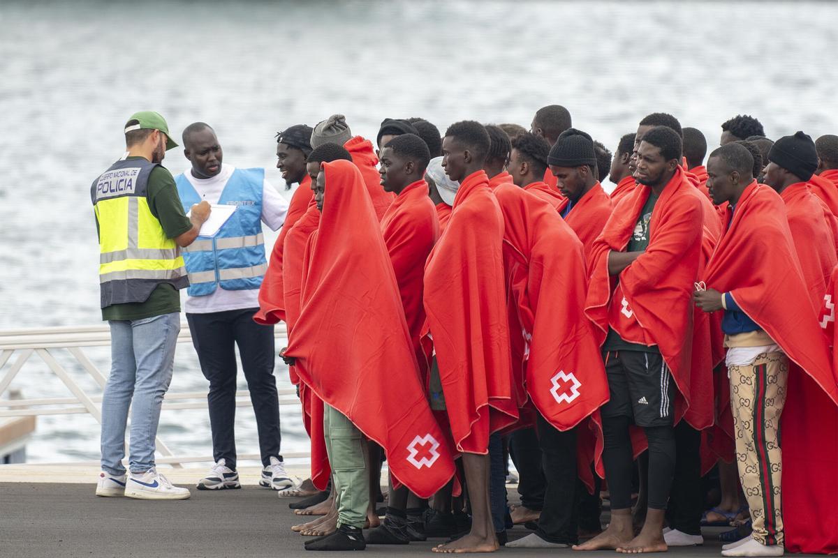 Un agente de Frontex toma los datos a un grupo de 114 personas de origen subsahariano, recién rescatadas, entre ellas quince mujeres, un bebé y un niño, en las costas de Lanzarote