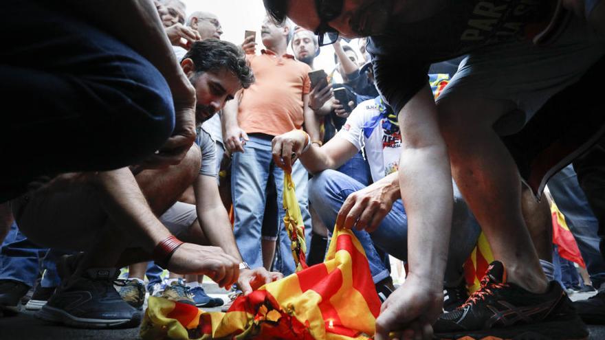 A la derecha de la imagen, Jiménez quema una estelada de los manifestantes del 9 d&#039;Octubre.