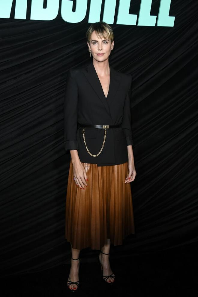 Charlize Theron con falda de cuero camel plisada