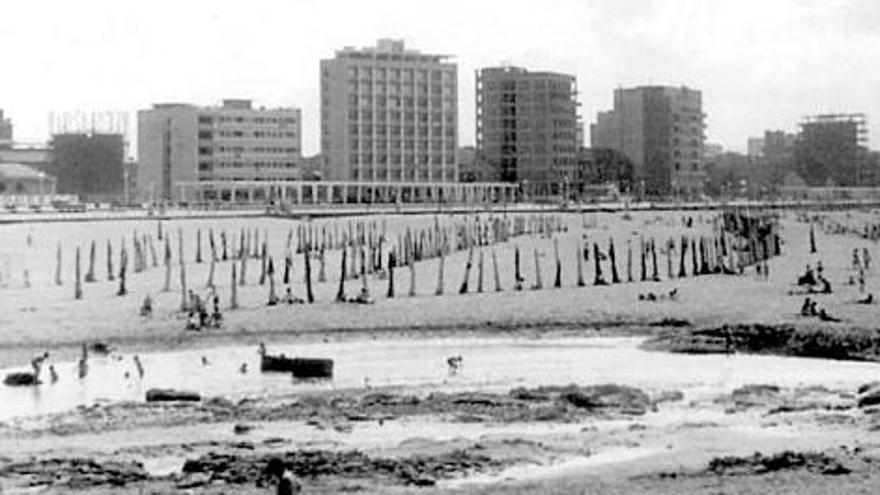 Una vista de la playa de San Lorenzo a principios de los años 60 del siglo XX. Al fondo, varios edificios en construcción en la avenida de Rufo García Rendueles, con el gasómetro de la Fábrica del Gas.