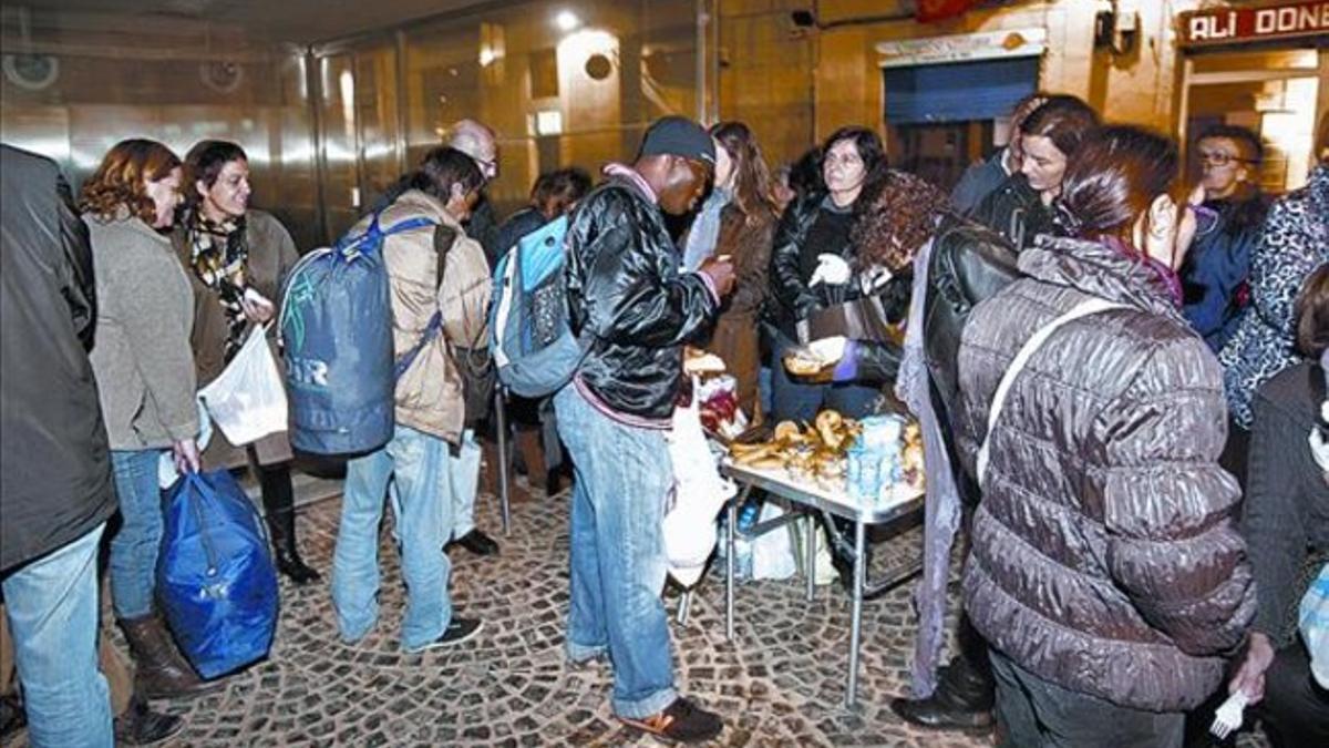 Reparto 8 Un grupo de voluntarios, el jueves, entrega comida en la plaza de Salvador Seguí.