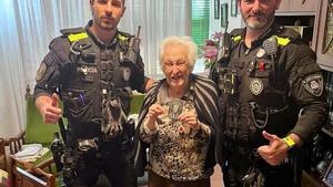 Los dos agentes de la Policía Local de Santa Coloma junto a la anciana de 104 años a la que auxiliaron