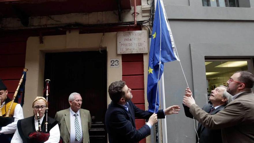 El eurodiputado Jonás Fernández; el alcalde de Oviedo, Wenceslao López, y Adrián Barbón izan la bandera de la Unión Europea en el portal de la casa donde nació el histórico dirigente socialista Indalecio Prieto.