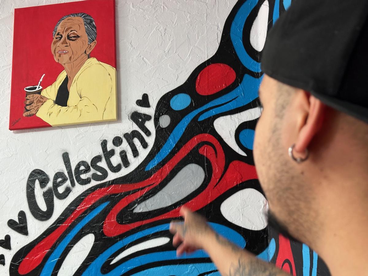 José Luis Noceda señala el cuadro dedicado a su abuela materna, uno de los elementos decorativos de su barbería y peluquería.