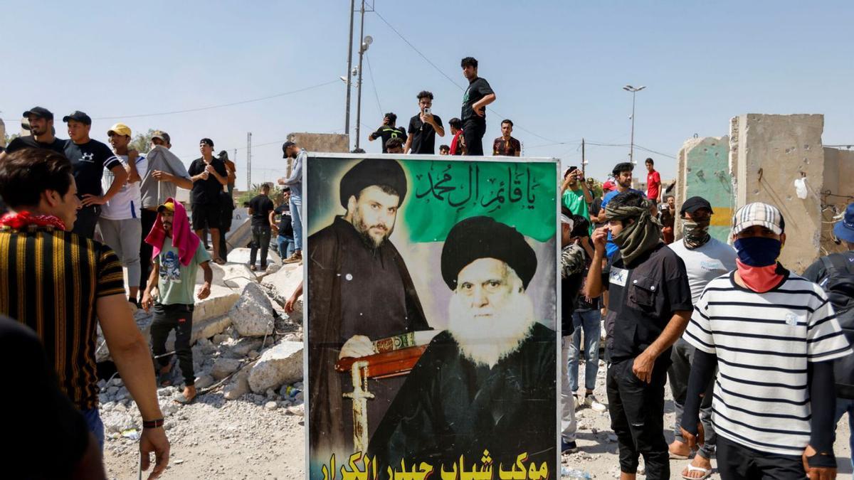 Seguidors de Muqtada al-Sadr retirant-se del carrer després d’episodis violents, a Bagdad. | REUTERS