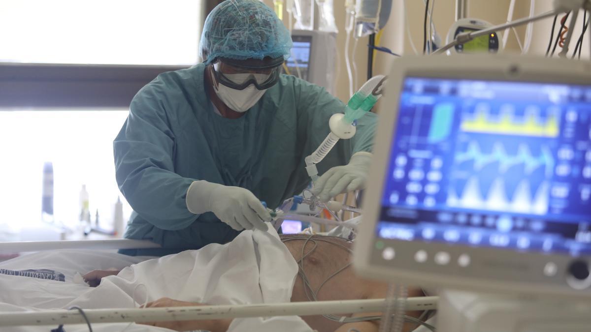 Una trabajadora de la UCI del Hospital General de Elche atiende a un paciente con covid.