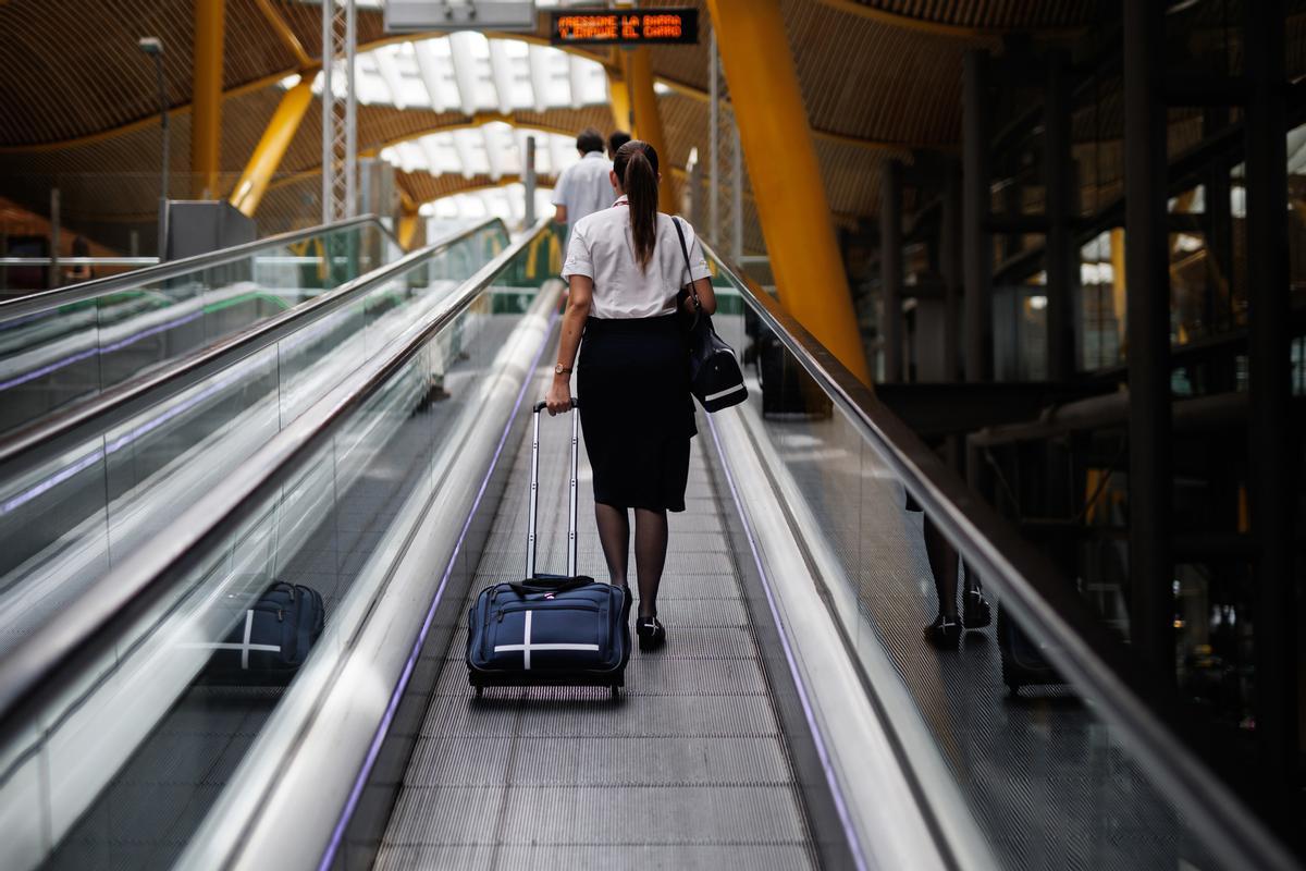 Archivo - Una azafata en las escaleras mecánicas de la Terminal 4 (T4) del aeropuerto Adolfo Suárez Madrid-Barajas.