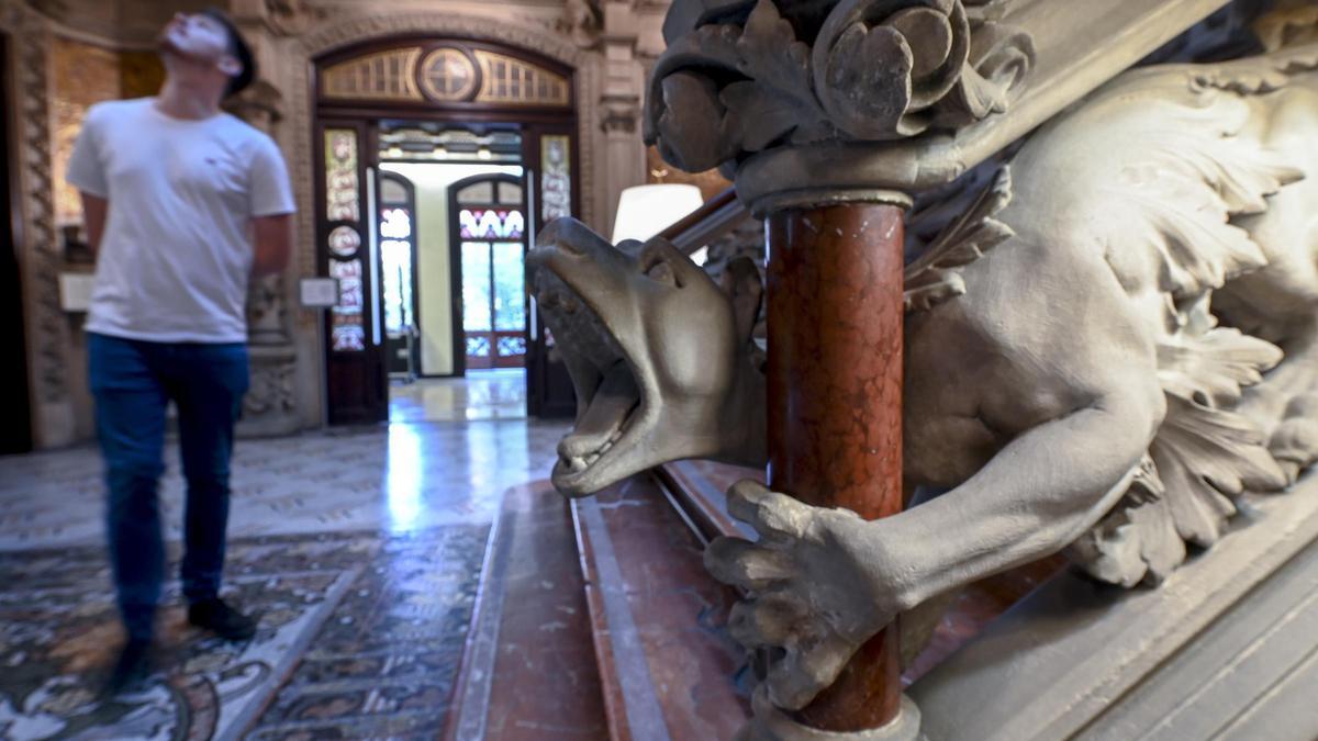 Un dragón esculpido en piedra abraza la imponente escalinata del Palau Montaner.