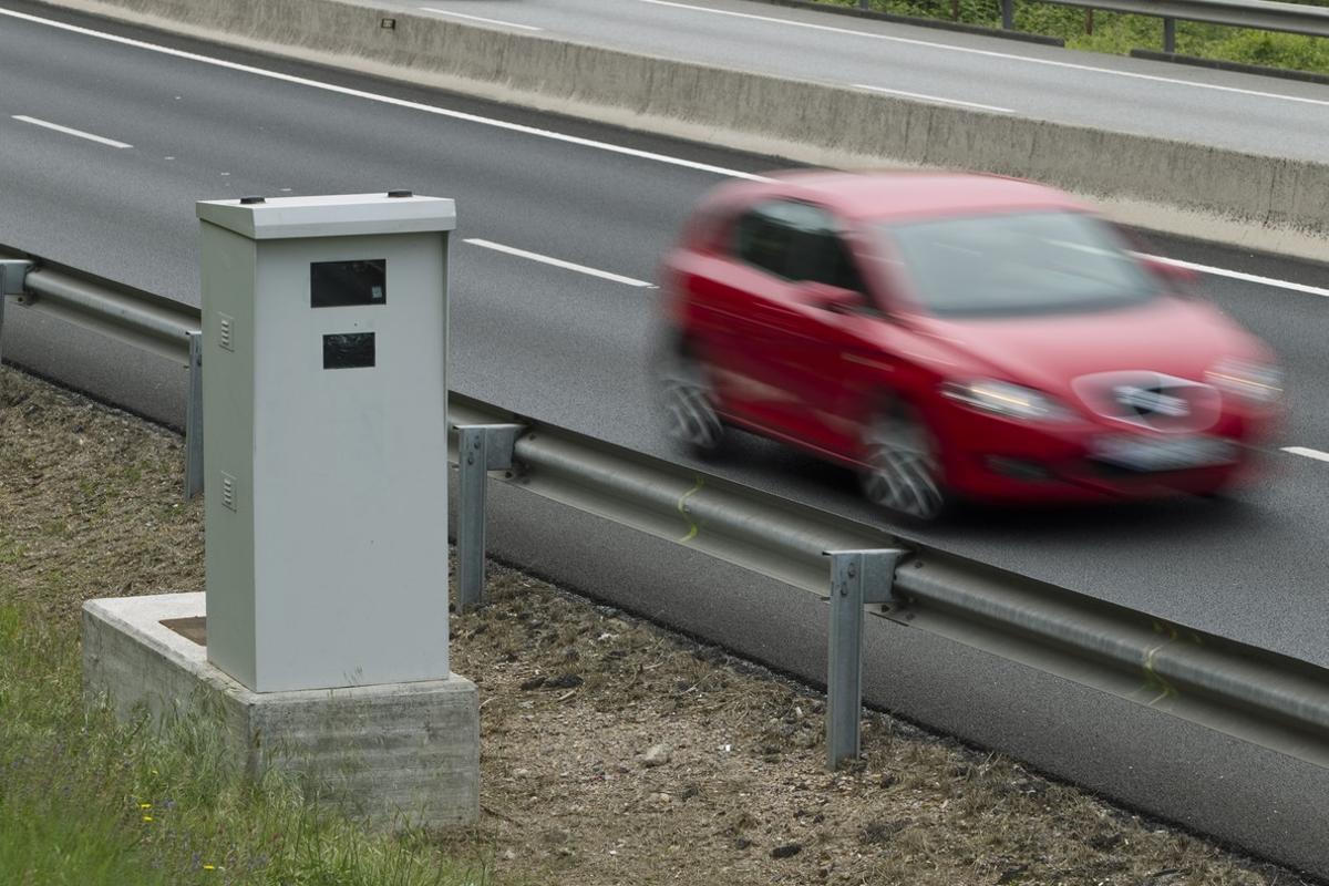 Un coche pasa junto a un radar de control de velocidad.