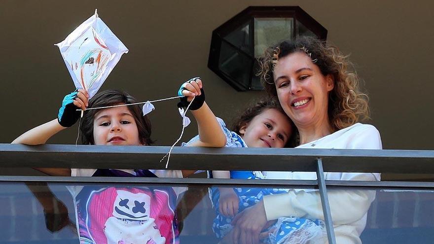 Una familia se asoma al balcón en Valencia.