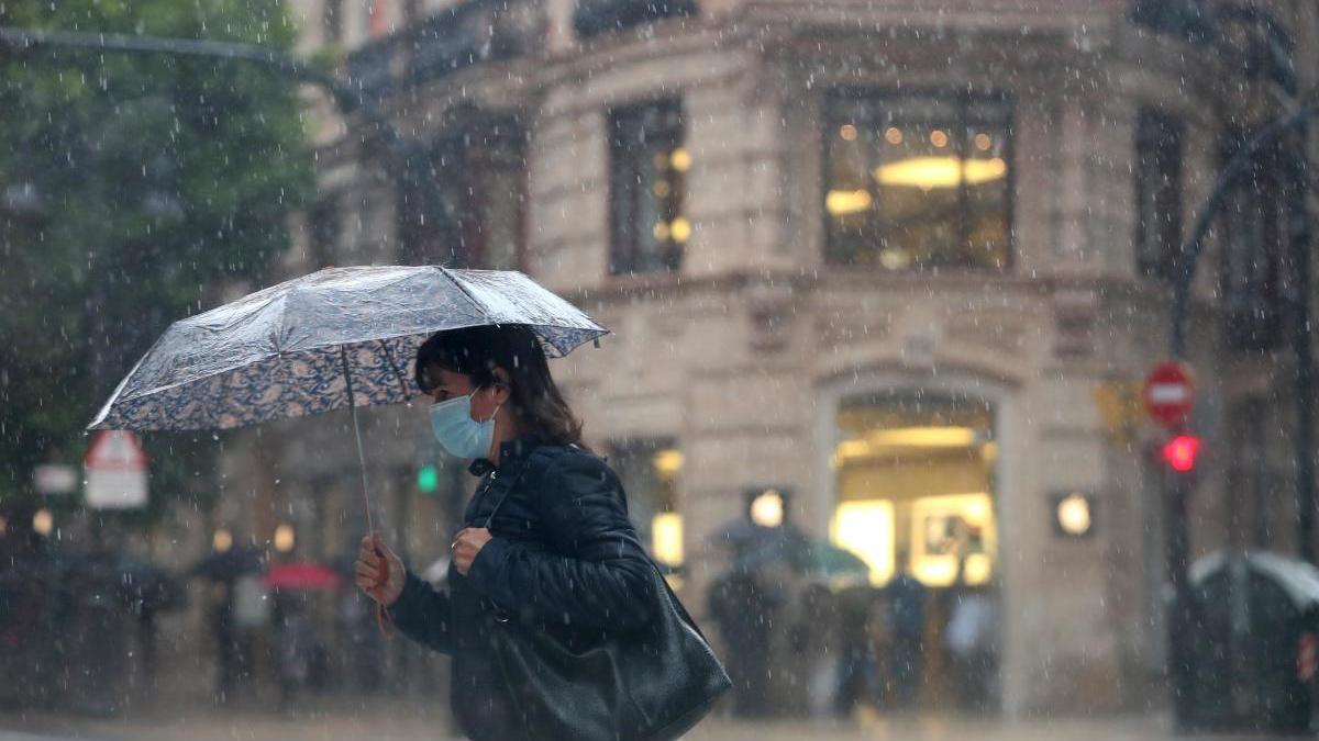 Una mujer camina bajo la lluvia que cayó en València hace unas semanas.