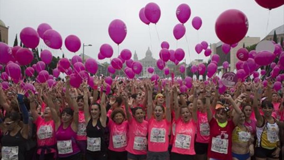Participantes en la carrera sujetan globos en solidaridad con las enfermas de cáncer de mama, ayer.
