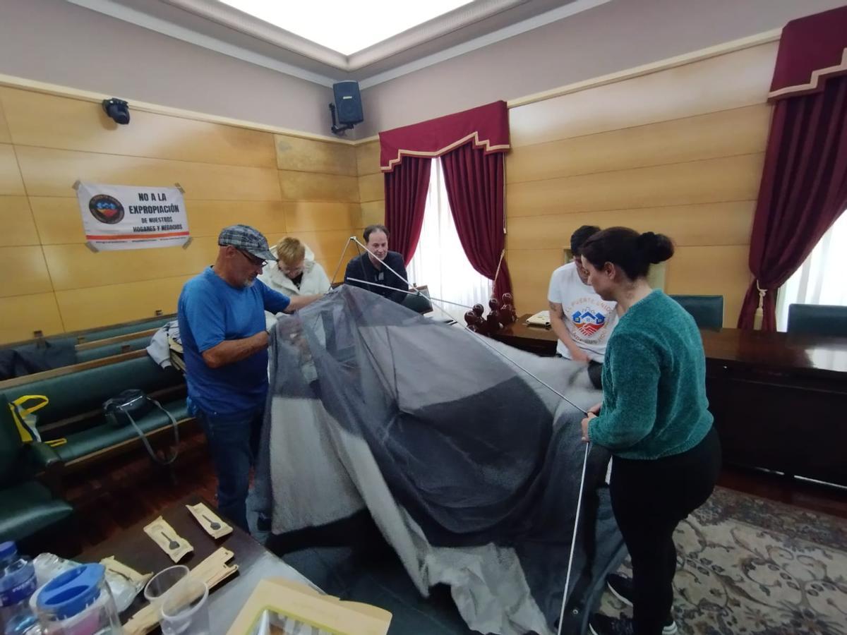 Vecinos de El Puente montando una tienda de campaña en el salón de Plenos del Ayuntamiento de Langreo