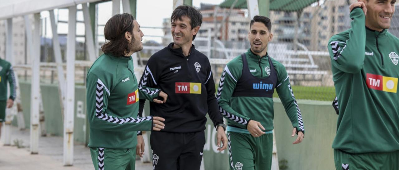 El entrenador del Elche, José Rojo, Pacheta, bromea ayer con Juan Cruz y Fidel antes del entrenamiento en el campo anexo.