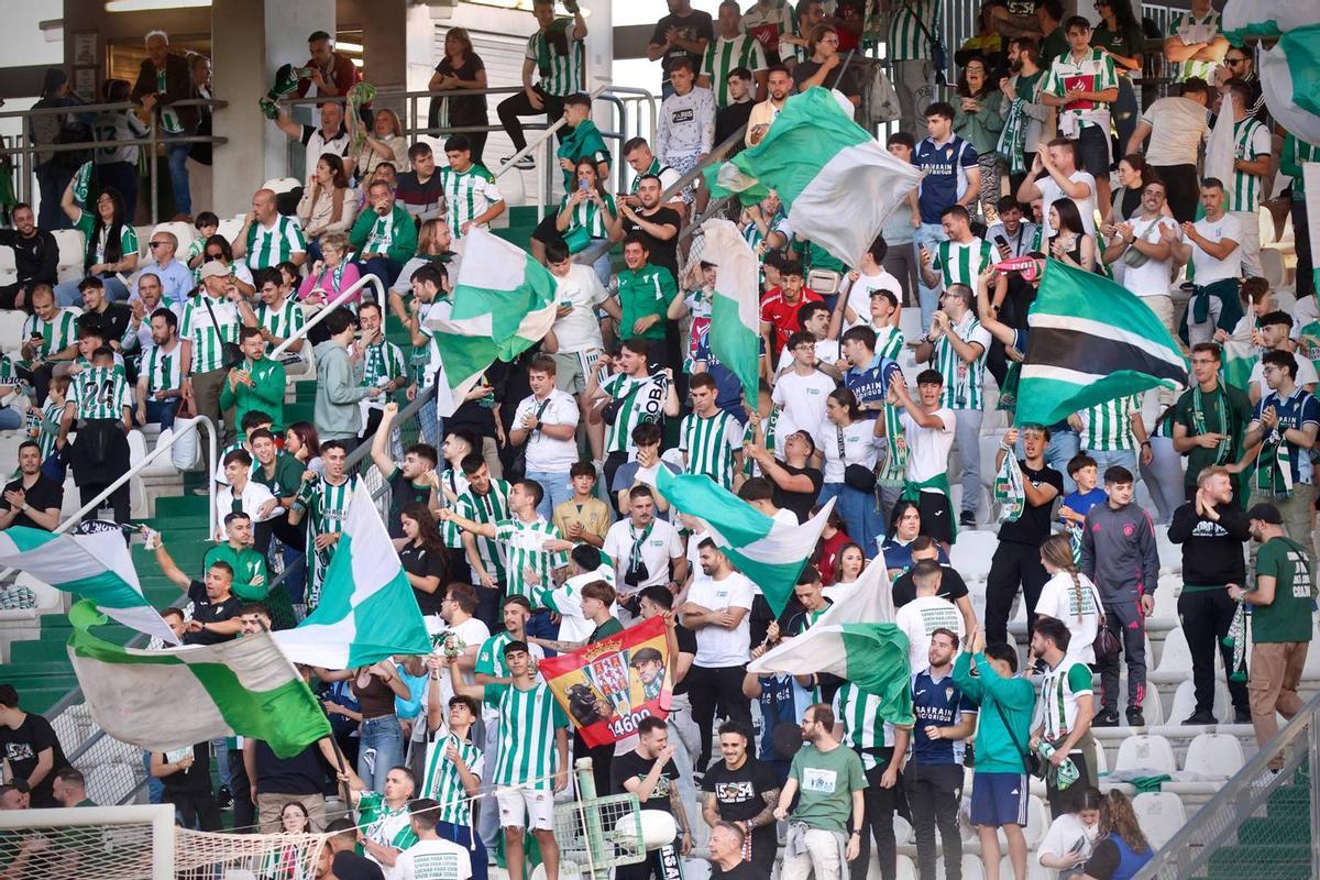 Un grupo de aficionados animan en la grada de El Arcángel.