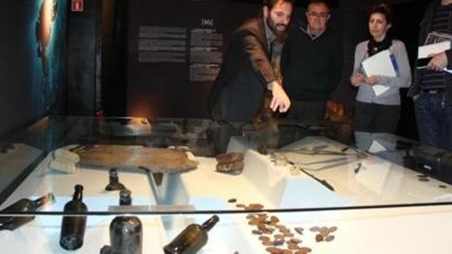 Uns visitants comenten els objectes que s&#039;exhibeixen en una de les vitrines de l&#039;exposició.