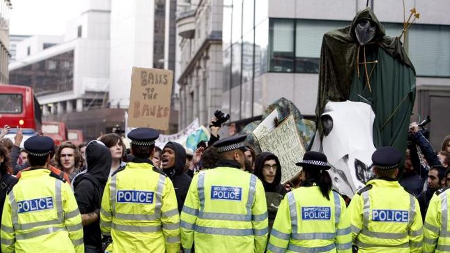 Un grupo de activistas anticapitalistas y contrarios al cambio climático camina ante la policía con un &quot;Jinete del Apocalipsis&quot; durante una manifestación de protesta cerca del Banco de Inglaterra en Londres .