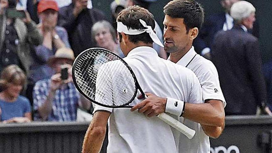 Djokovic y Federer se abrazan al final del partido.