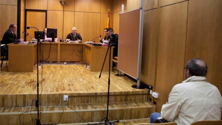 El acusado, de espaldas, al inicio del juicio de ayer en Langreo.