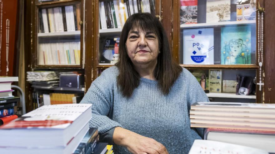 Maria Alba Serra Roca davant d&#039;un taulell amb piles de llibres pel Sant Jordi del 2018 |