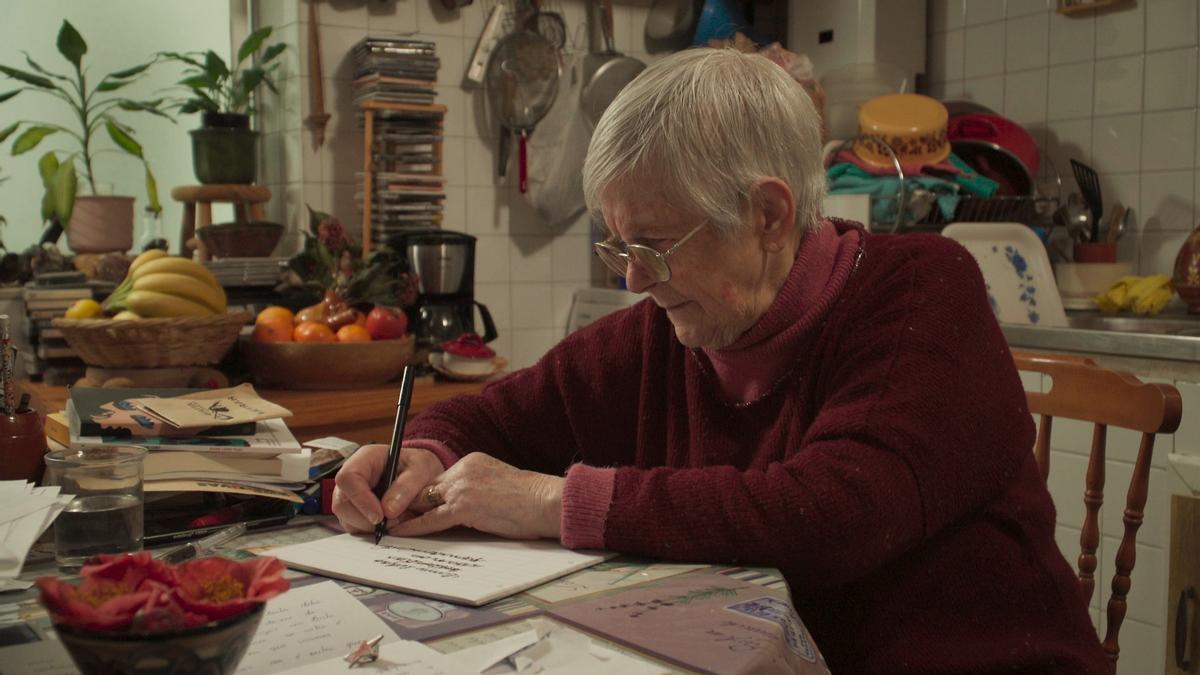 LA ESCRITORA LUZ FANDIÑO ESCRIBIENDO UN POEMA EN UN FOTOGRAMA DEL DOCUMENTAL " A POETA ANALFABETA ".