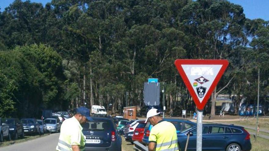 Dos operarios, ayer, pintando las zonas con aparcamiento de pago.