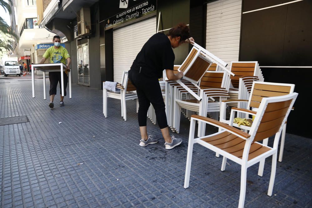 Imágenes de una lluviosa mañana de jueves en el centro de Málaga, donde al paisaje ya habitual de pocas personas y la mayoría de ellas con guantes y mascarillas se le han añadido los preparativos de bares, cafeterías y terrazas que se preparan para el inminente cambio de fase de la desescalada de la ciudad.