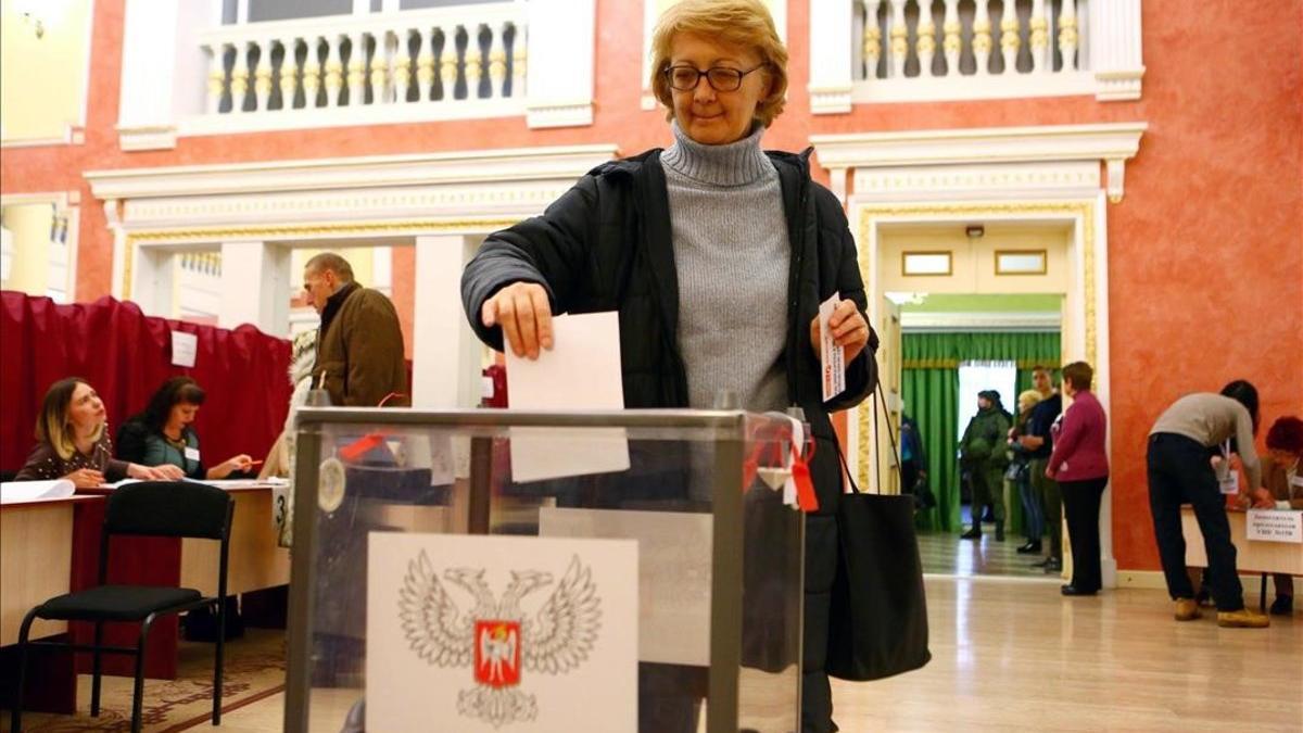 Una mujer deposita su voto en un colegio electoral de la ciudad ucraniana de Donetsk.